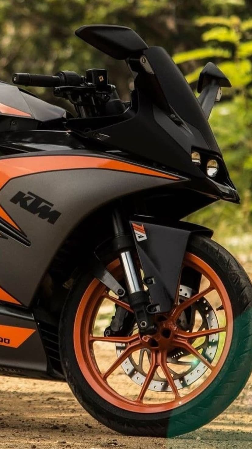 KTM motorcycle alloy wheel and front suspension forks shown in a detailed close-up with soft bokeh background.