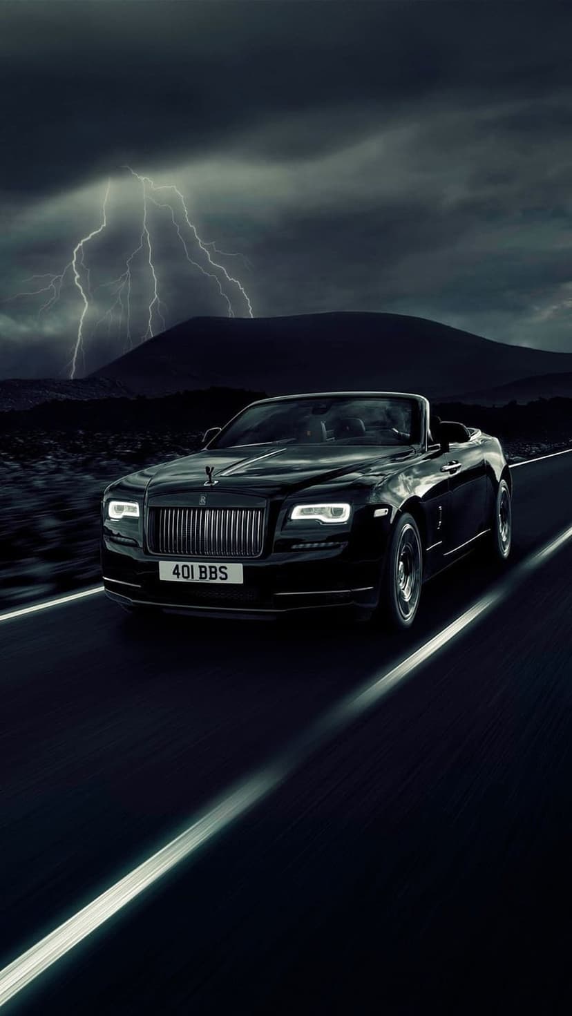 Black Rolls-Royce convertible travels a highway at night while lightning strikes over distant mountain peaks.