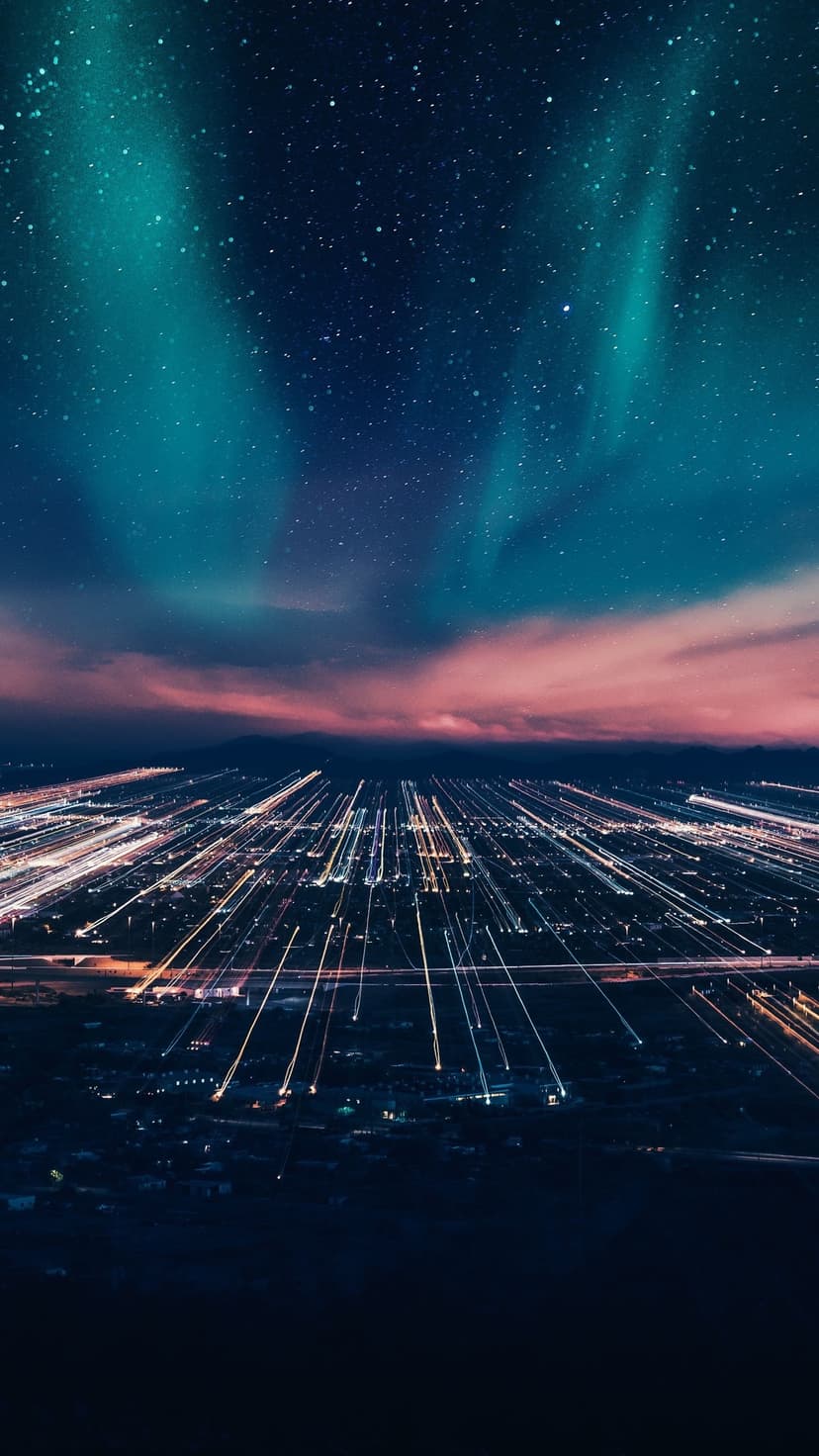 Vibrant neon light trails streak through a dark metropolitan street beneath a vast, star-filled night sky.