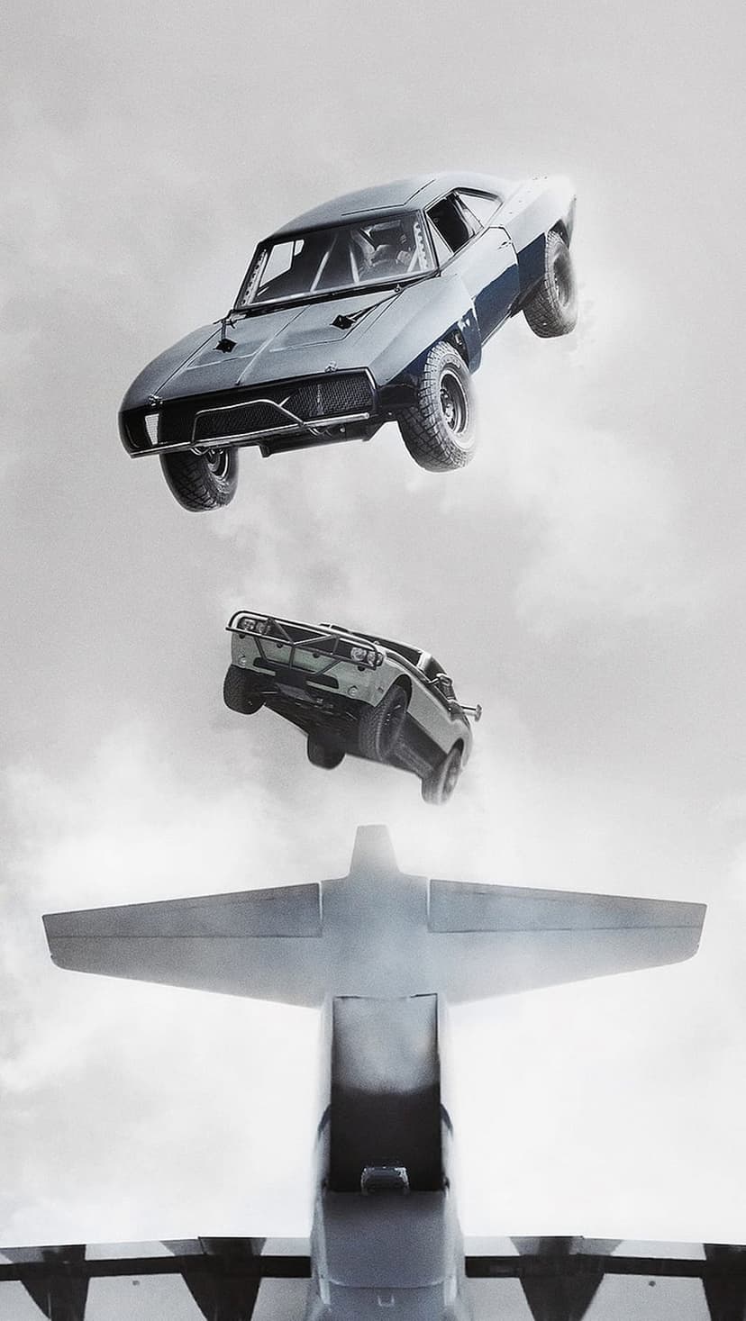 Two cars plummet through the clouds after jumping from a large cargo aircraft during an intense aerial stunt.