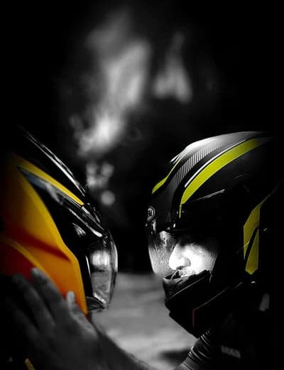Motorcycle helmets face-to-face in dramatic lighting