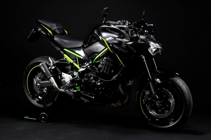 Kawasaki Z900 sportbike with a black body and lime green frame against a dark studio background.