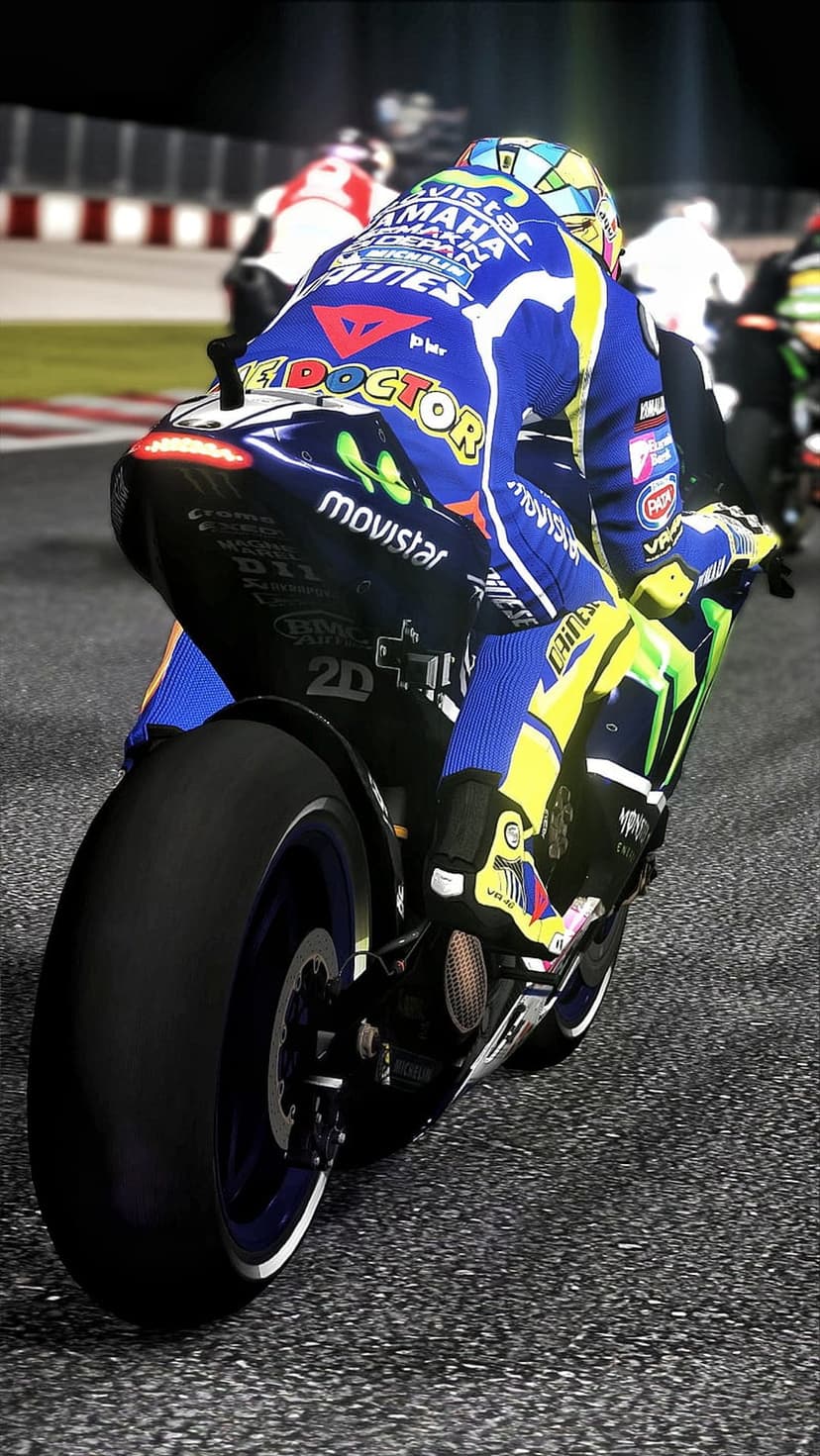 Motorcycle racer in a blue and yellow suit leans into a turn on a track with blurred bikes in the background.