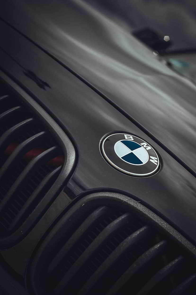 BMW circular emblem and vertical black kidney grille on a luxury sports car with dramatic shadow lighting.