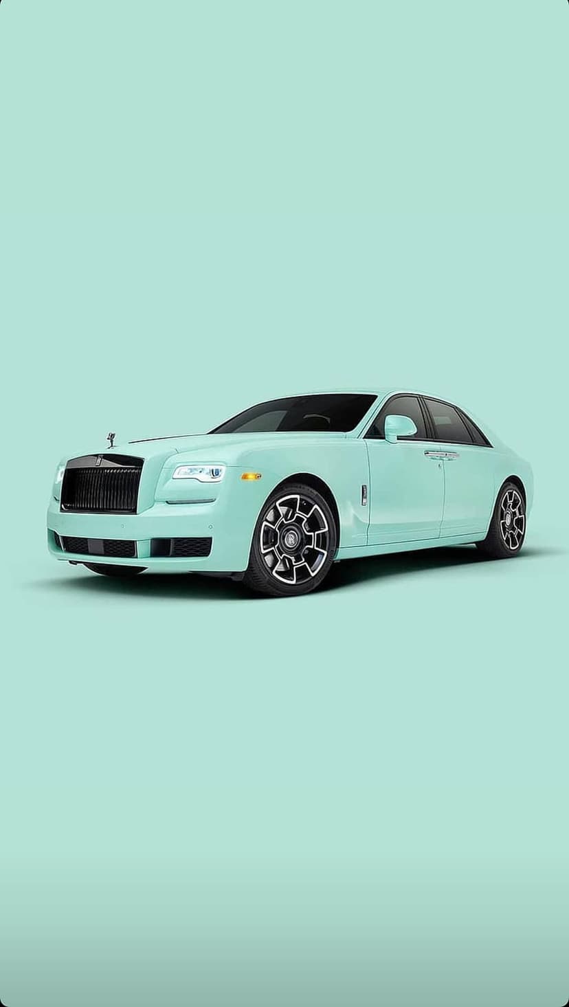Rolls-Royce Ghost in mint green with a chrome grille and alloy wheels against a pastel minimalist background.