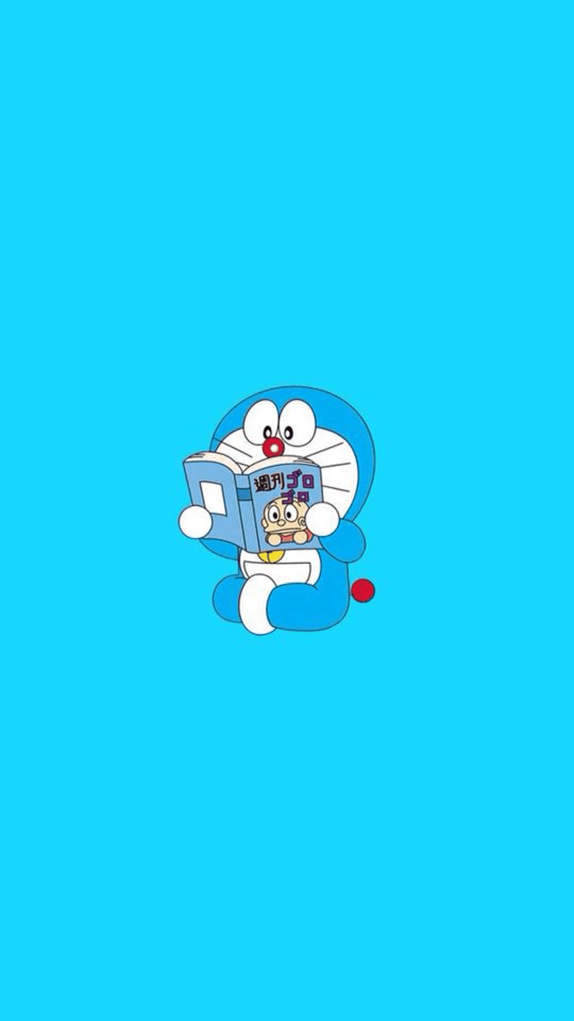 Doraemon sits reading a white book with a small character on the cover against a flat vibrant blue background.