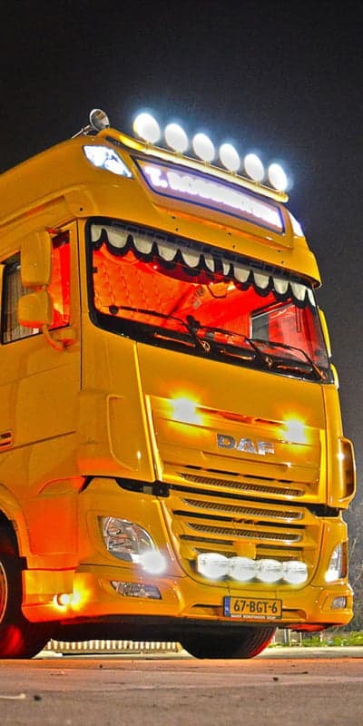 Yellow DAF Truck Illuminated at Night with Many Lights