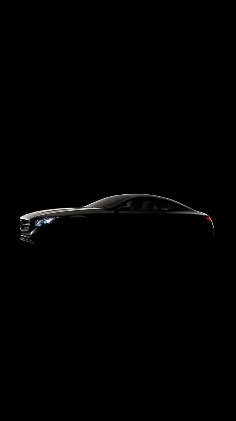 Luxury sports coupe silhouette with glowing headlights against a black background in a vertical minimalist style.