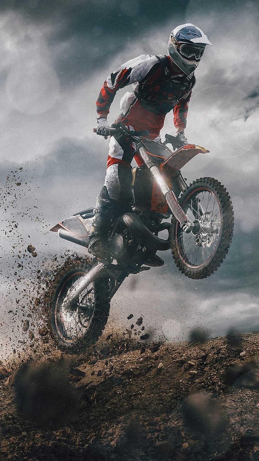 Motocross athlete jumps a dirt bike mid-air with dust trails against a dramatic, cloudy sky in sharp focus.