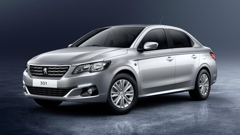 Silver Peugeot 301 sedan parked in a professional studio with a dark blue textured background and reflective floor.