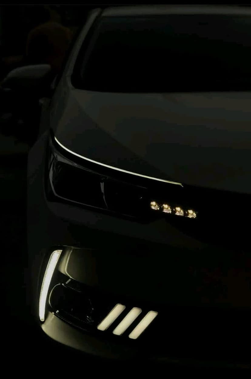 LED car headlights with a sharp blue-white glow illuminate a dark, sleek vehicle front end in close-up.