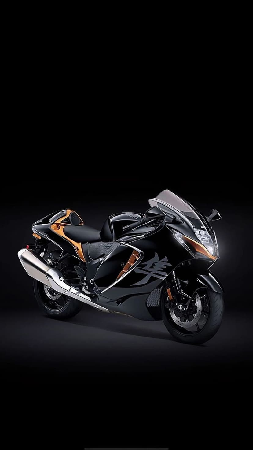 Suzuki Hayabusa superbike with gold highlights and black fairings positioned against a dark studio background.