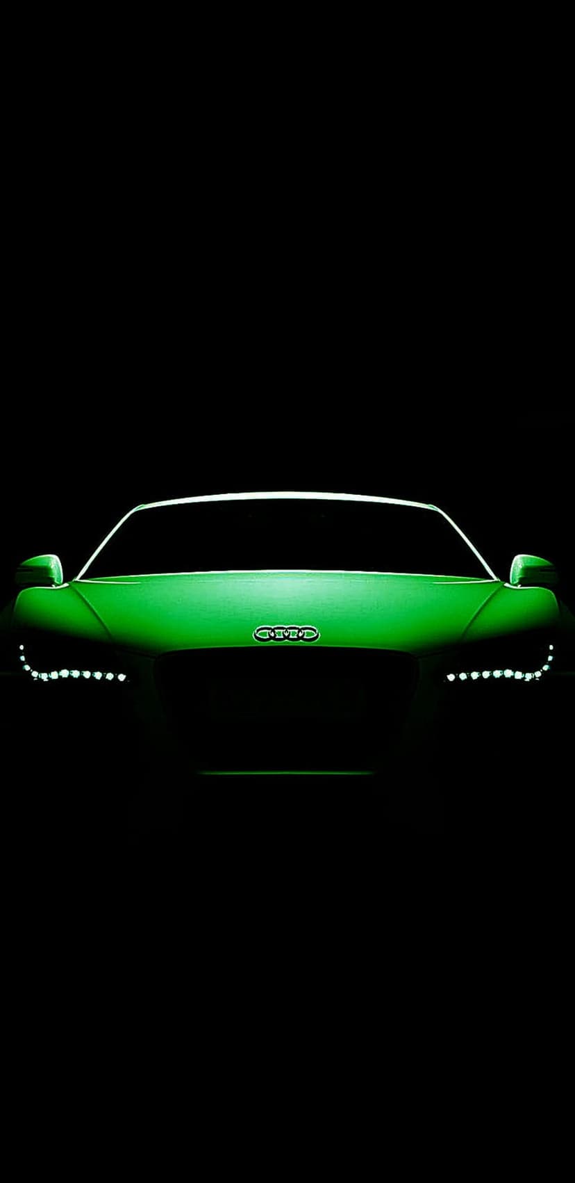 Green Audi R8 sportscar with glowing LED headlights and a silver grille emblem on a solid black background.