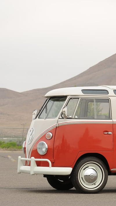 Vintage Red and White Volkswagen Bus on Scenic Road