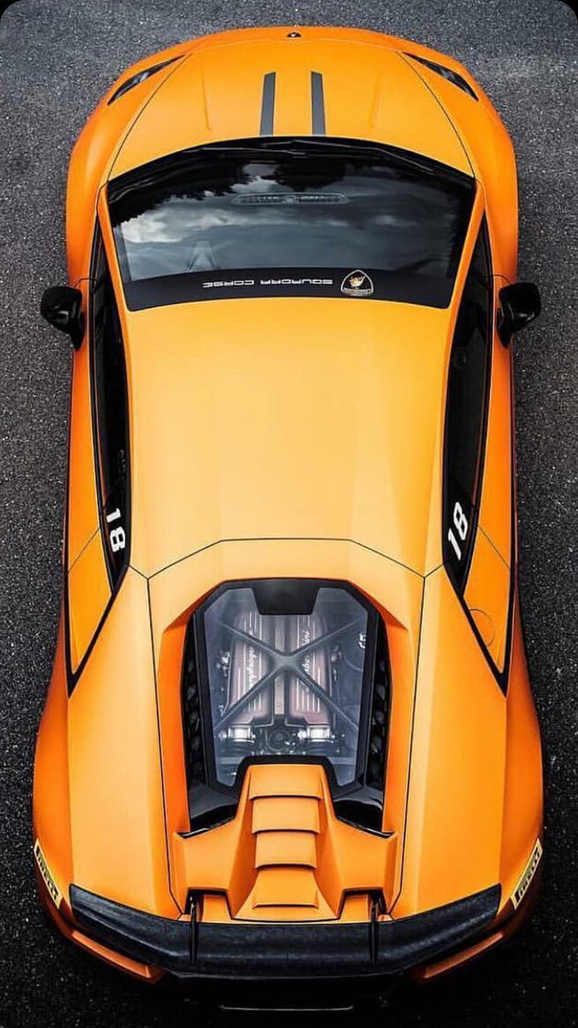Orange Lamborghini Huracan supercar from a top-down view featuring a visible engine bay and racing number 18.