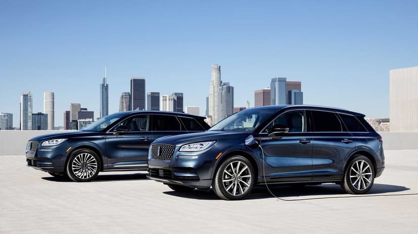 Two navy blue luxury SUVs parked on a rooftop with the Los Angeles city skyline under a clear blue sky.