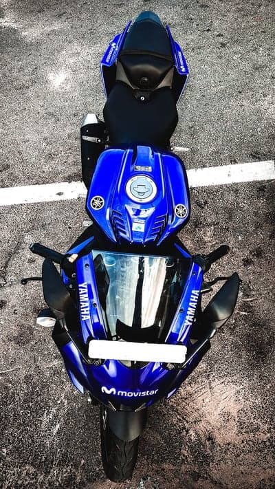 Blue Yamaha R15 motorcycle parked on asphalt