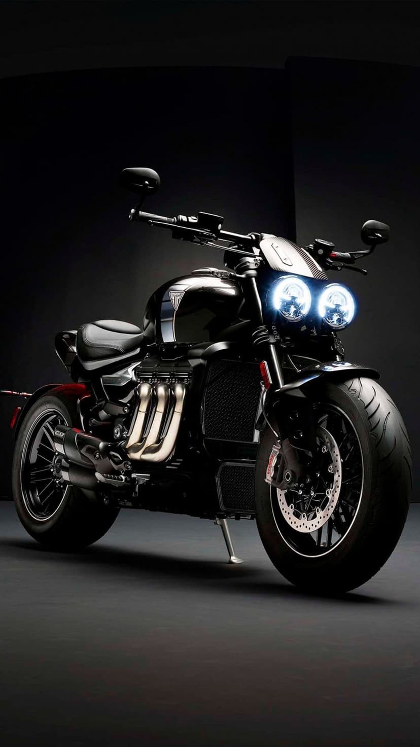 Triumph Rocket 3 motorcycle with glowing dual headlights, chrome exhaust pipes, and a muscular engine design.
