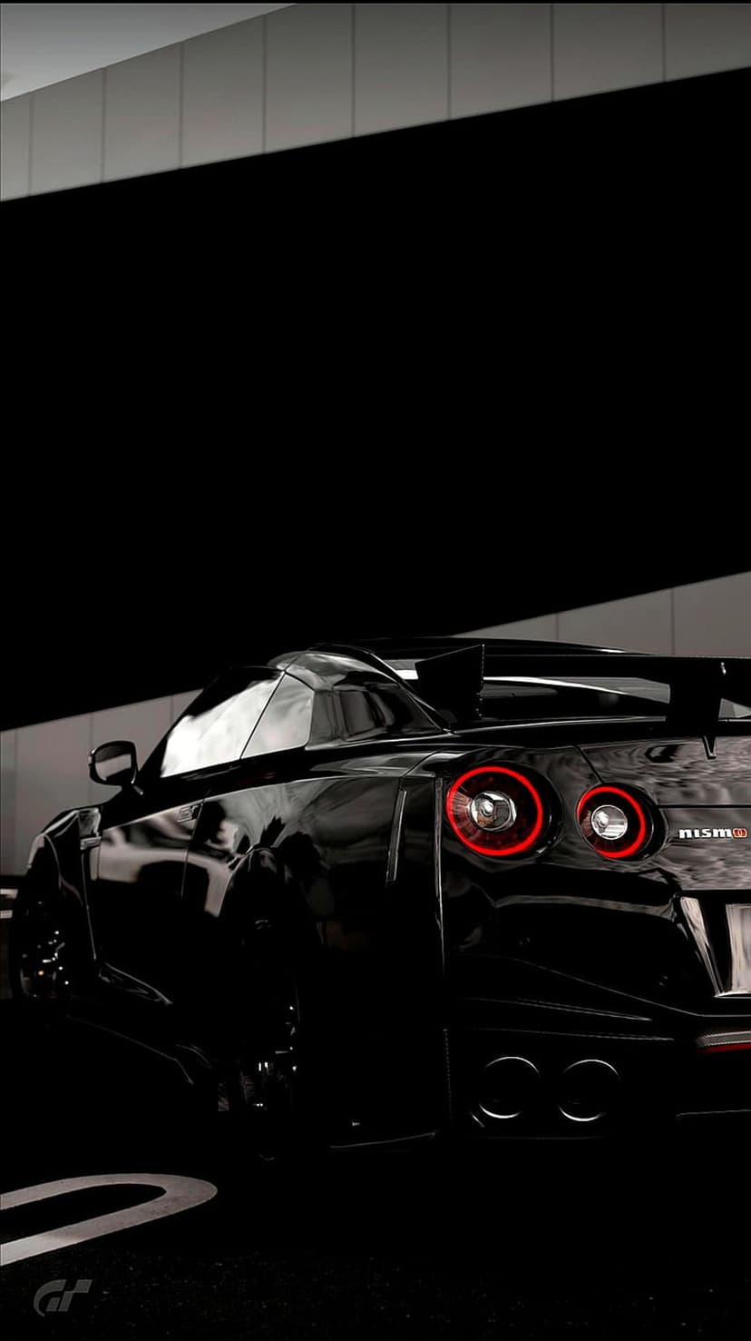 Nissan GT-R Nismo rear featuring red circular taillights, a large spoiler, and dual exhausts on black paint.