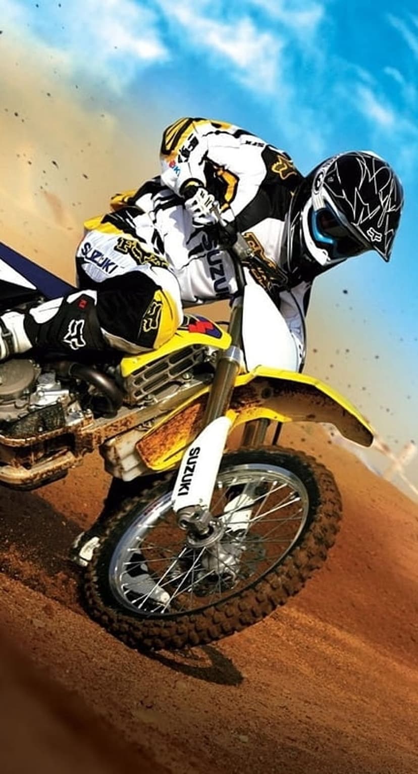 Motocross rider in full gear jumps a yellow Suzuki bike against a blue sky with dust trails on a dirt track.