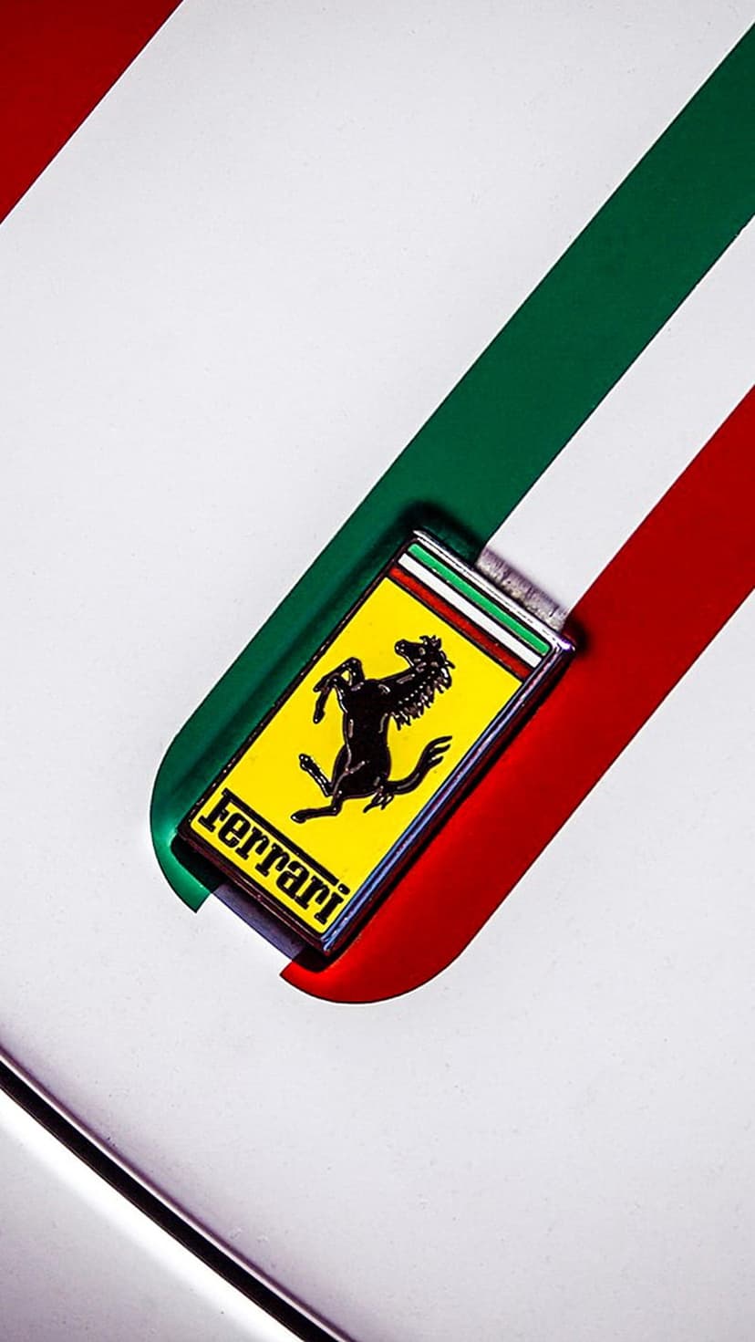 Ferrari prancing horse emblem on a yellow shield layered over green, white, and red vertical Italian flag stripes.