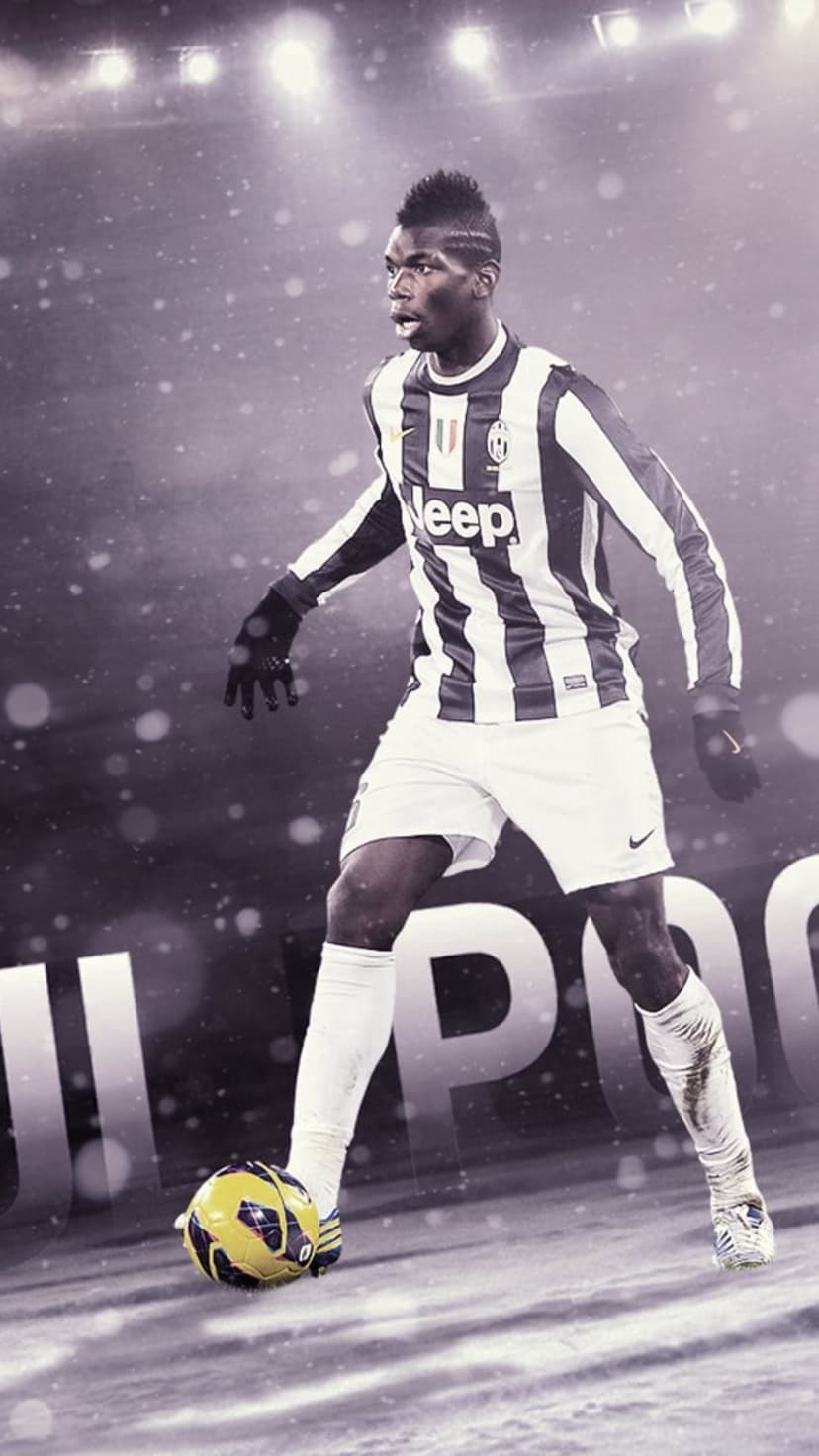 Paul Pogba wearing a black and white Juventus kit controls a soccer ball while large snowflakes fall around him.