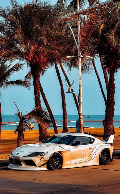 White Widebody Supra on Beach Road with Palm Trees