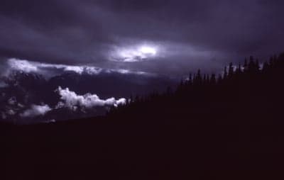 Dark Mountain Landscape with Stormy Clouds and Moonlit Sky