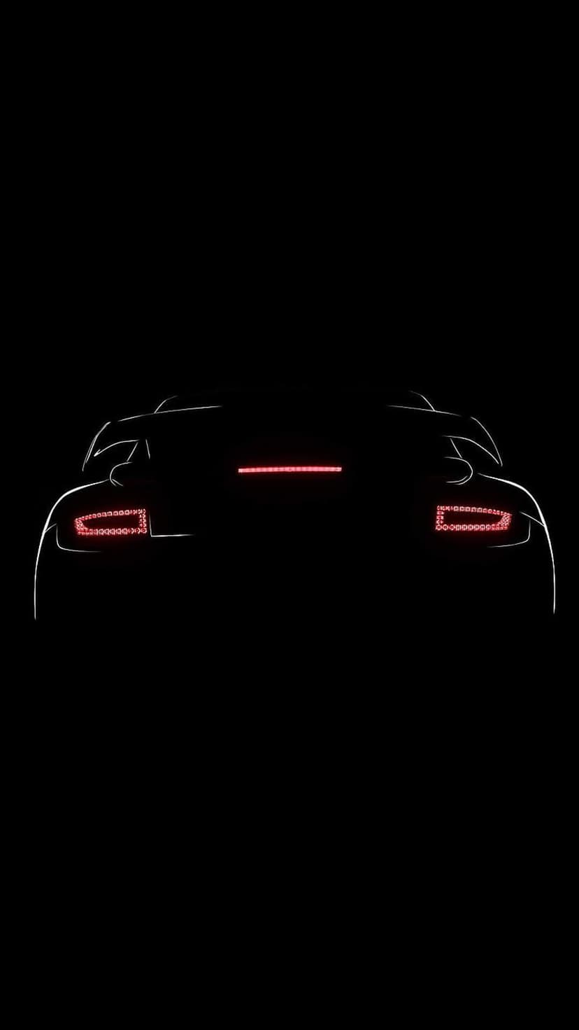 Sports car rear profile with glowing red LED taillights and a thin light bar against a solid black background.