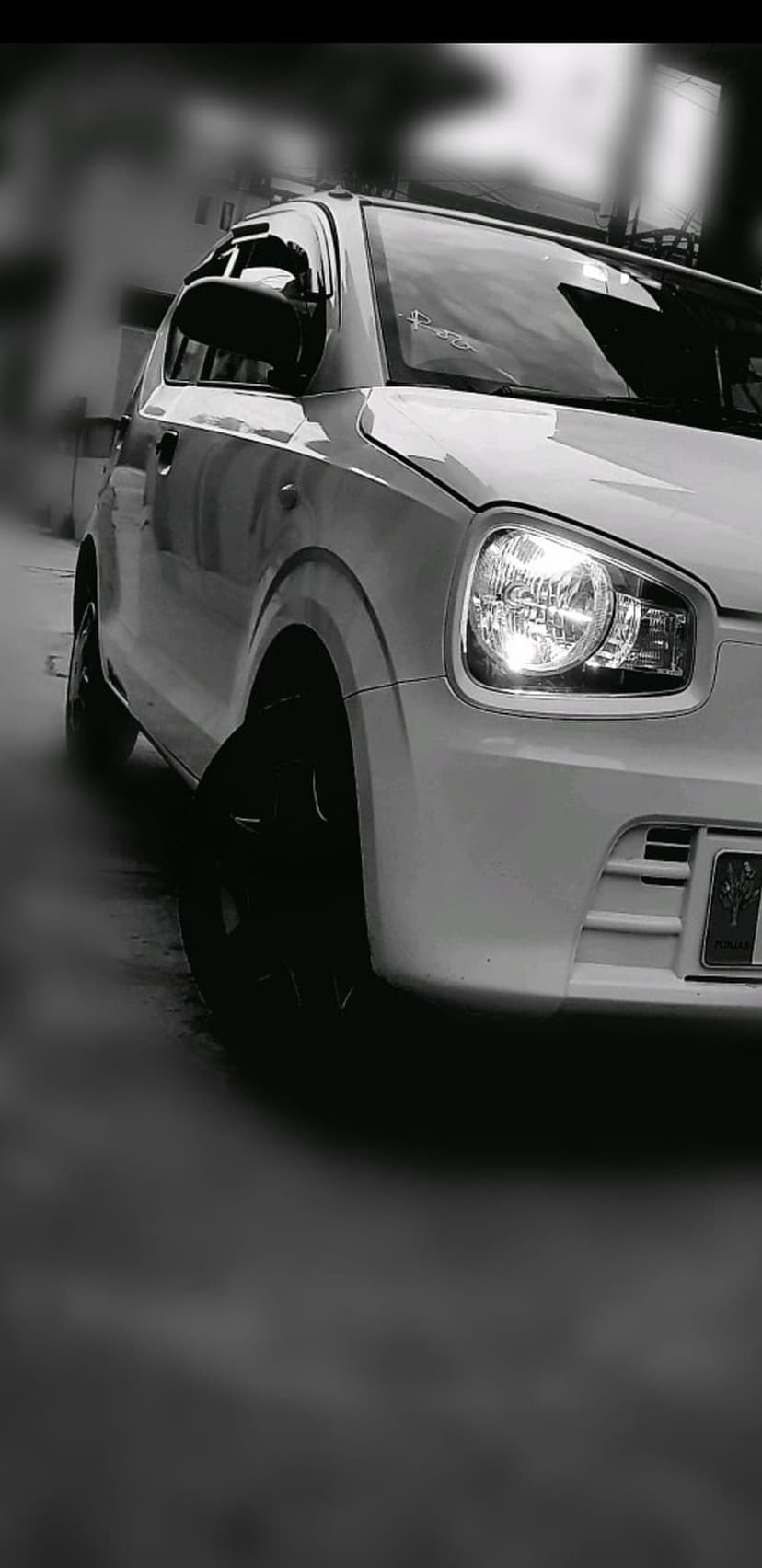 Car headlight assembly displays sharp glass edges and reflective chrome details against a dark blurred background.