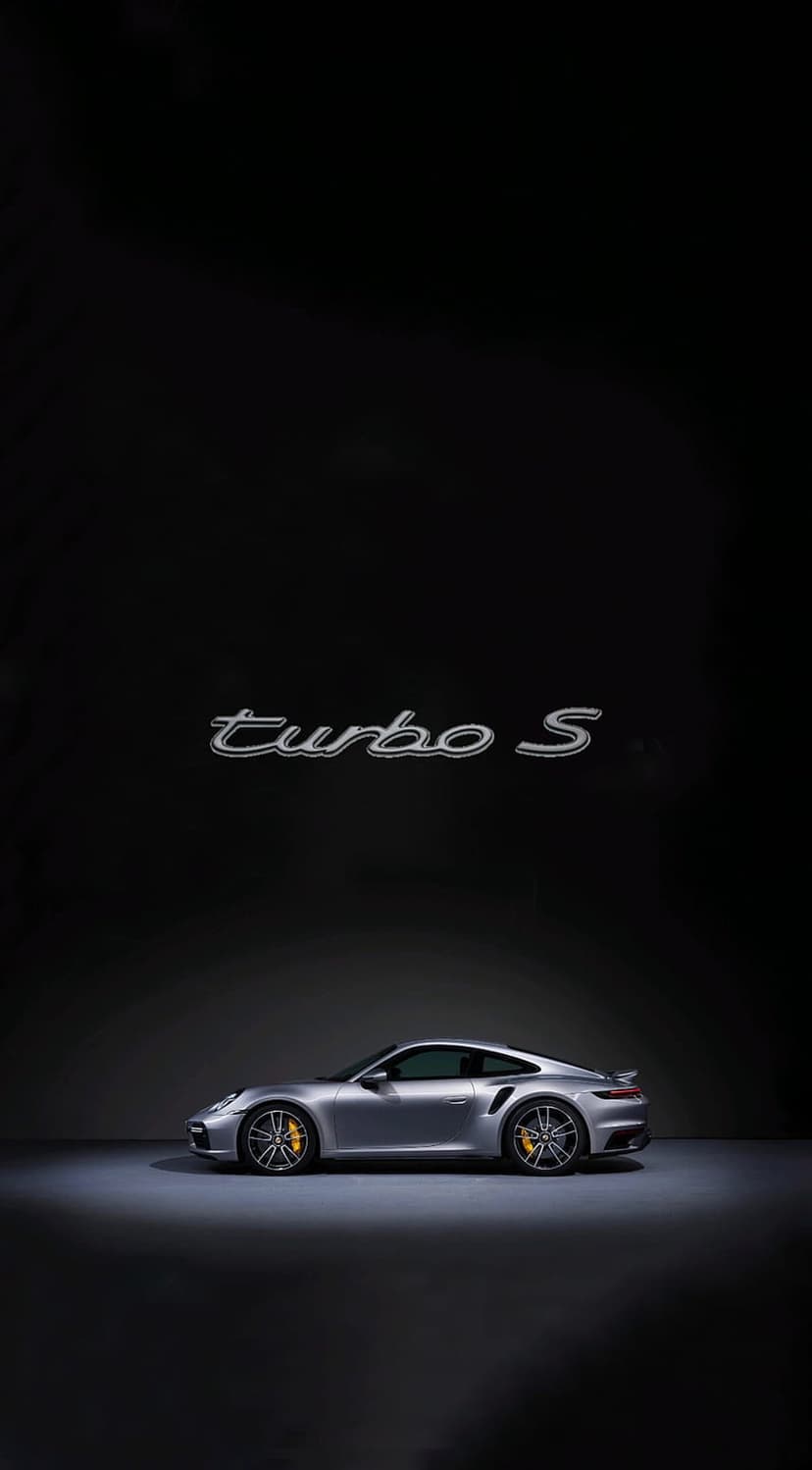 Silver Porsche 911 Turbo S supercar with yellow brake calipers and alloy wheels in a vertical profile view.