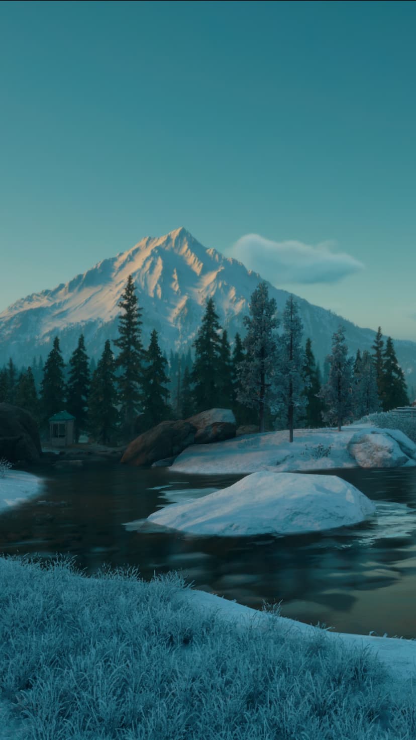Snow-capped mountain peak towers over a winding icy river and frosted pine trees in a blue-lit winter valley.
