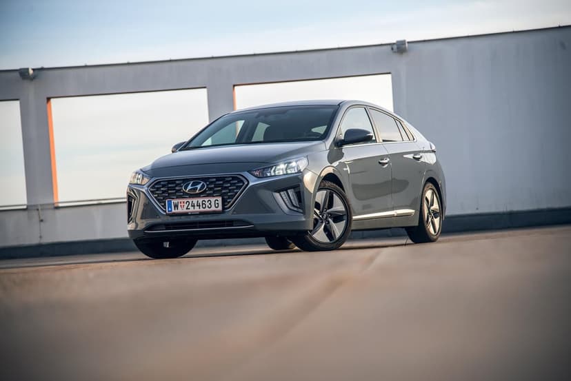 Gray Hyundai Ioniq sedan parked on a concrete rooftop under a clear sky with soft sunset lighting.
