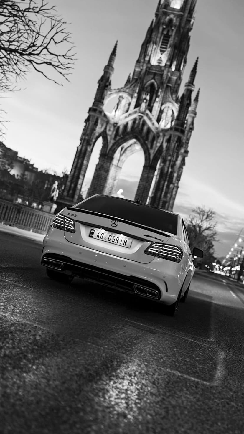 Mercedes E63 AMG rear view on a wet street with the Scott Monument in Edinburgh as a cinematic backdrop