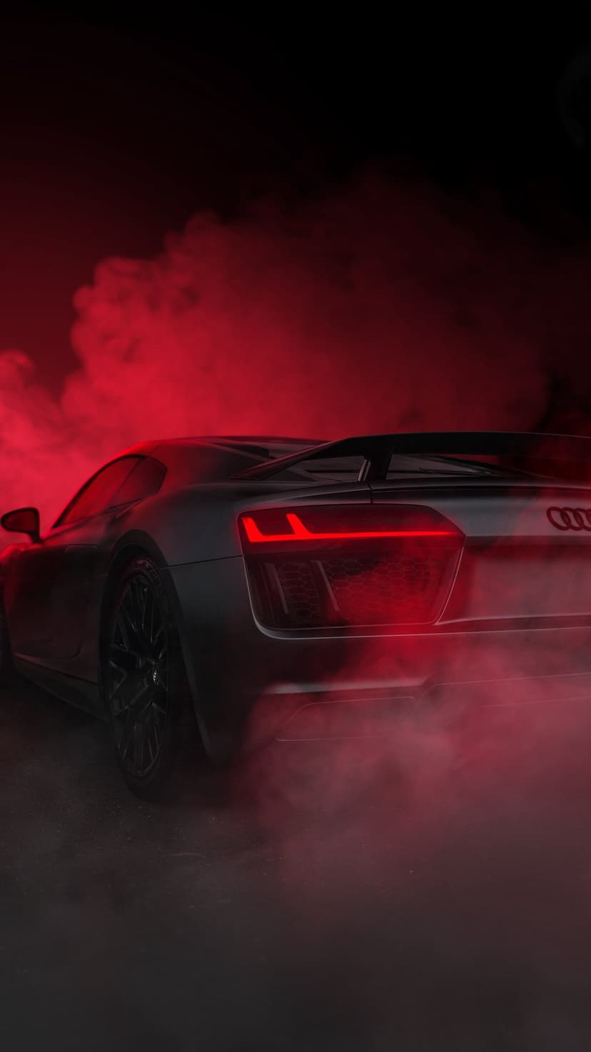 Audi R8 rear LED lights glowing through dense red smoke clouds against a dark and moody atmospheric background.
