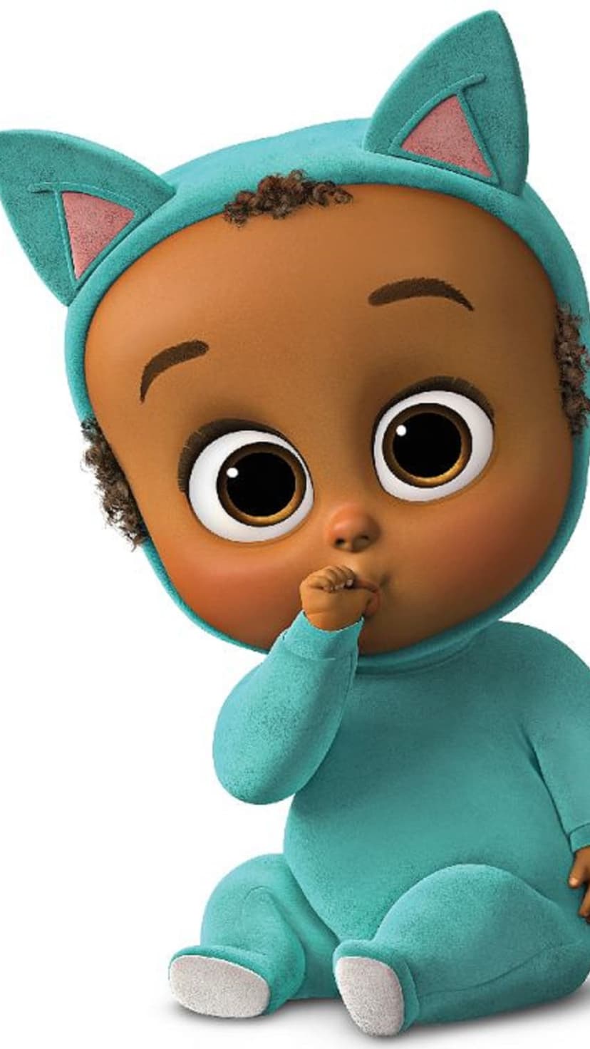 Curly-haired baby with dark skin wears a teal cat onesie and sucks their thumb against a white background.