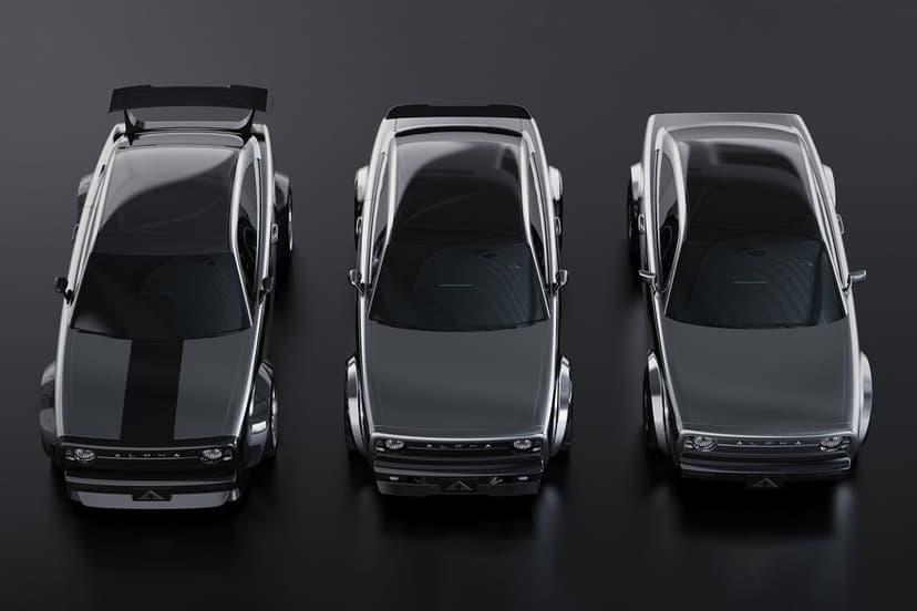 Three sleek silver concept cars viewed from above on a dark studio floor with soft reflective lighting.
