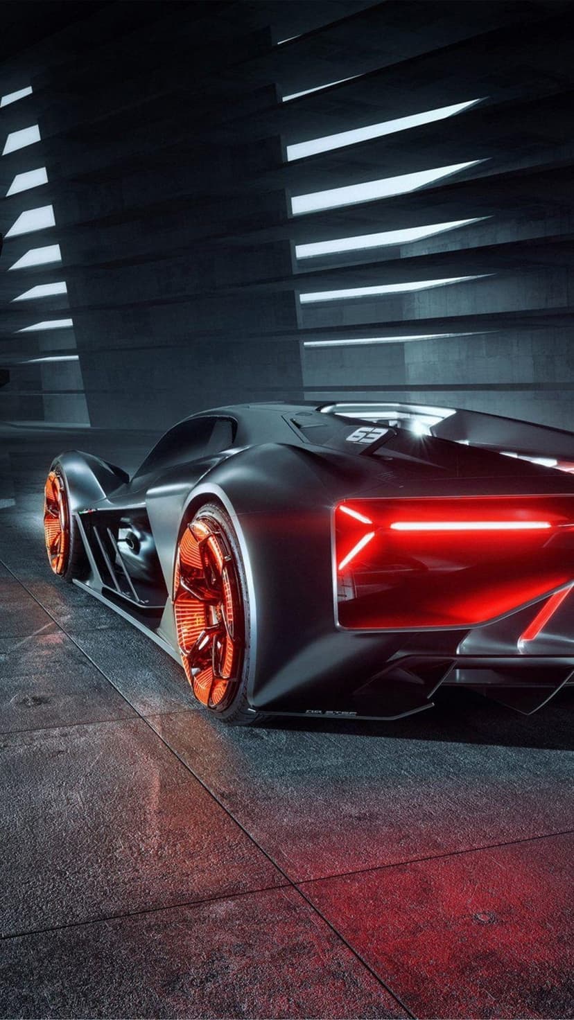 Black futuristic sports car with glowing red taillights and orange rim accents parked in a dark garage.