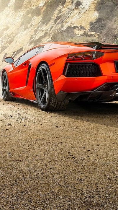 Vibrant Orange Lamborghini Aventador Driving on Desert Road