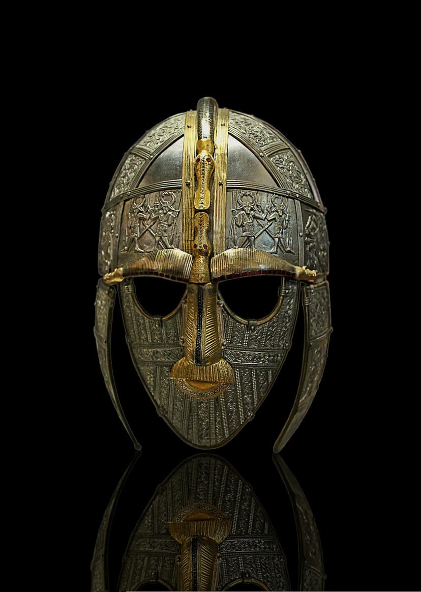 Sutton Hoo helmet featuring an iron face mask and bronze dragon motifs against a moody black background.