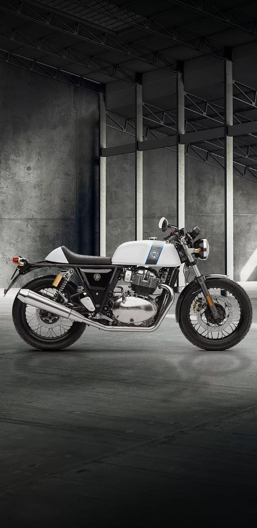 Royal Enfield Interceptor 650 with blue stripes parked on concrete in a minimalist industrial garage.