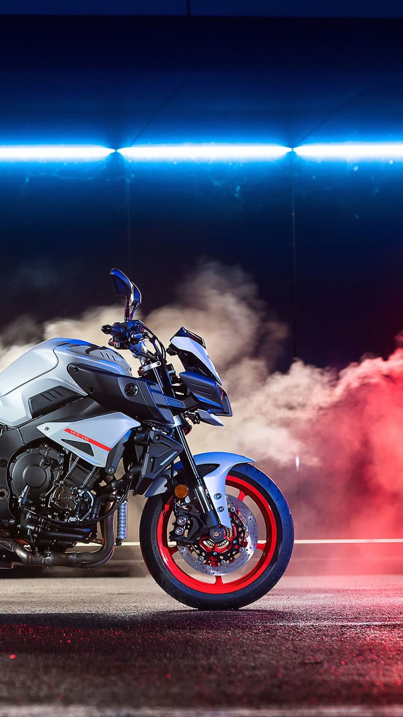 Yamaha MT-10 motorcycle front fairing illuminated by red and blue neon lights with thick white smoke swirling.
