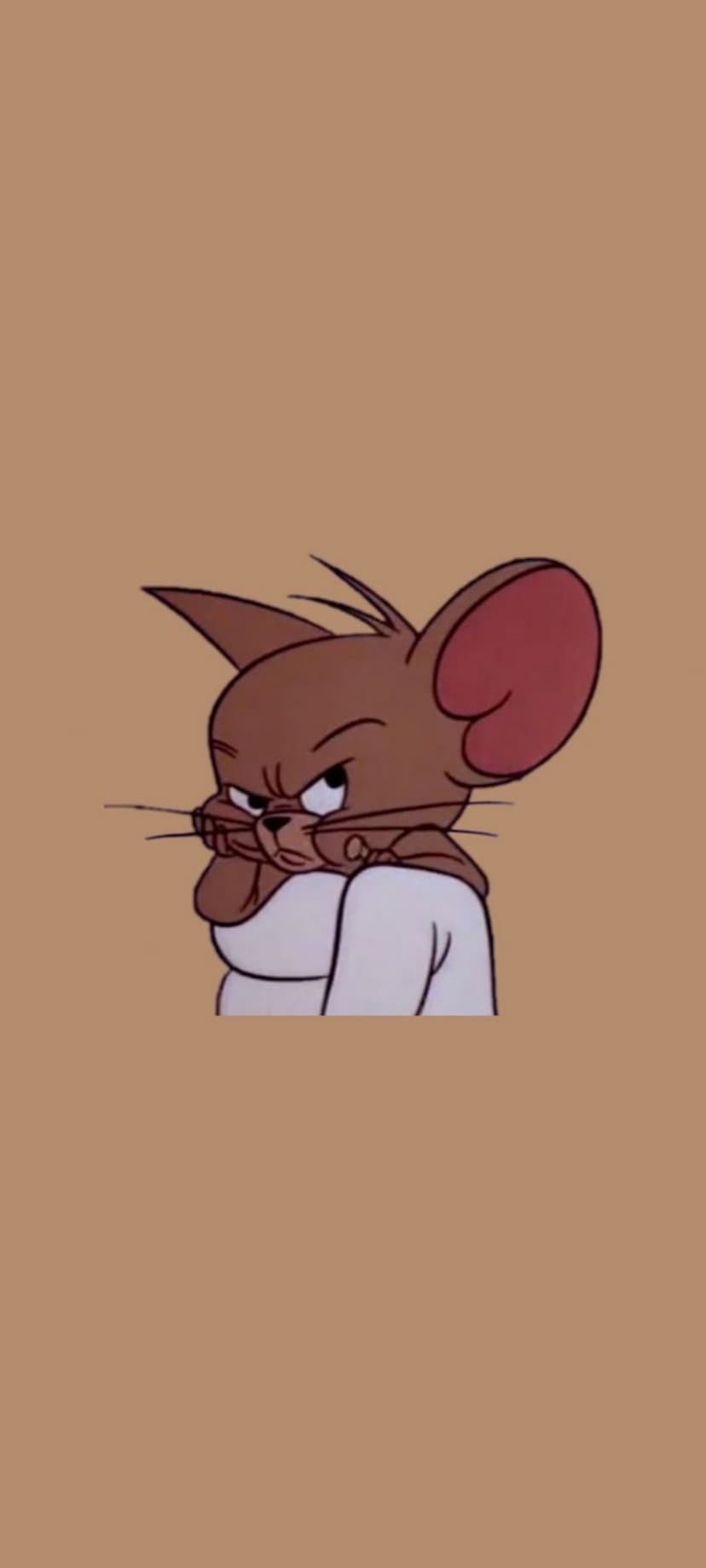Jerry the mouse with a grumpy face and arms under his chin wears a white shirt against a plain tan background.