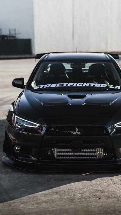Black Mitsubishi Evo X with "Streetfighter LA" banner