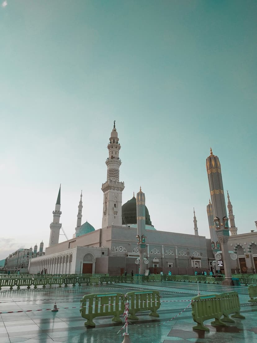Green Dome and tall white minarets of Al Masjid an Nabawi rise over a vast marble courtyard in Medina.