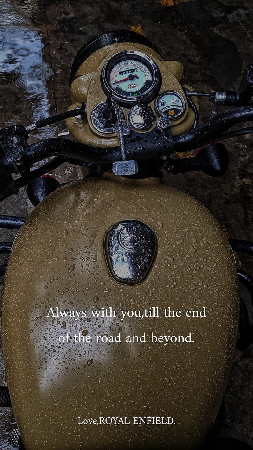 Tan Royal Enfield motorcycle tank covered in raindrops with white text about road companionship and loyalty.