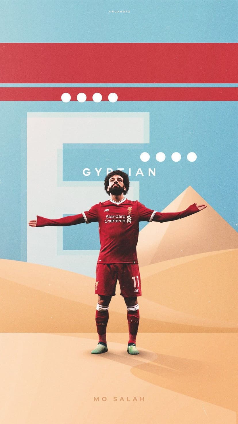 Mohamed Salah wearing a red jersey stands with arms outstretched before pyramids in a golden desert landscape.