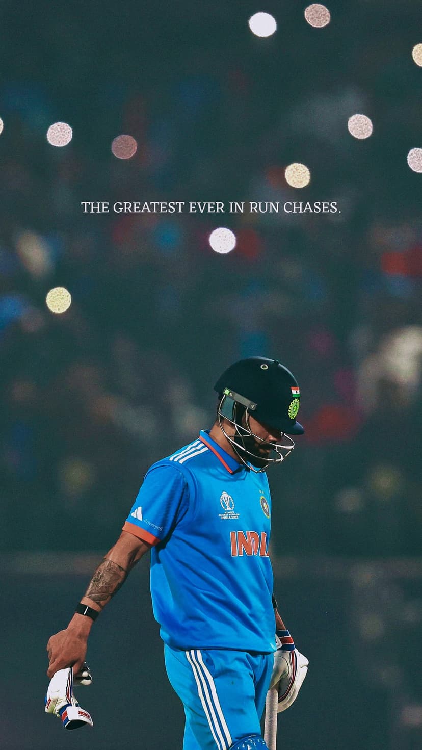 Virat Kohli in a blue Indian cricket jersey stands before blurred stadium lights with an intense expression.