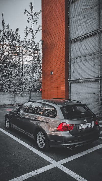 BMW Station Wagon Parked Near Red Brick Building