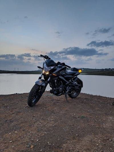 Motorcycle parked by lake at dusk